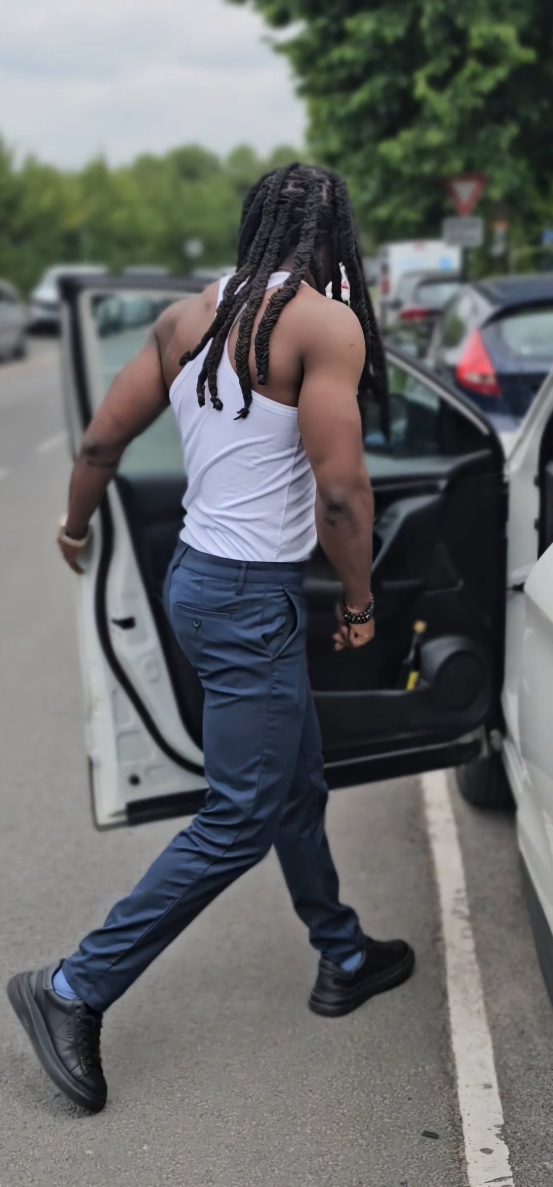 Homme aux longues locks en débardeur blanc