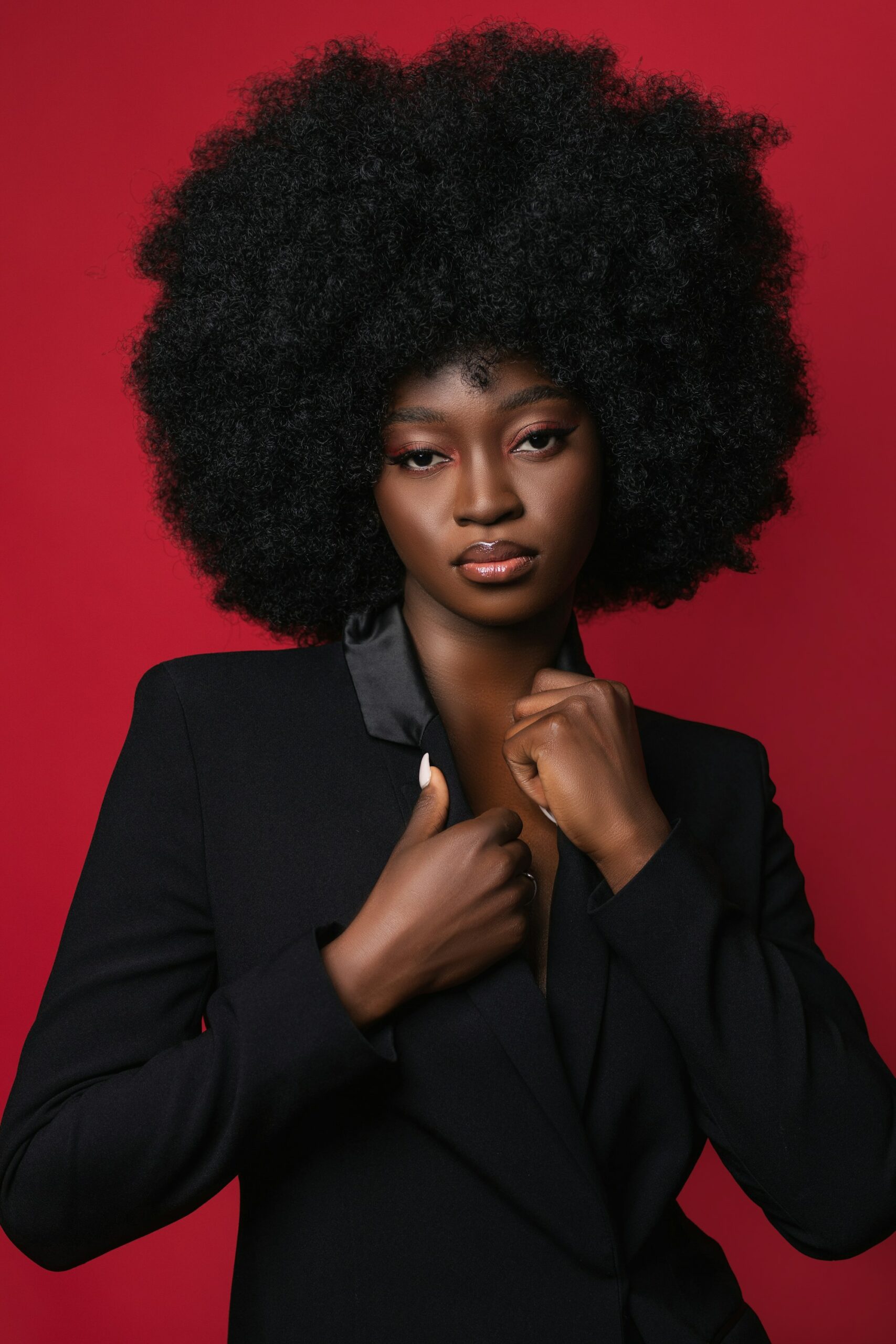 Portrait d'une femme aux cheveux afro sur fond rouge